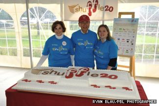 From left, President Judith Woodsworth, Shuffle Advisory Committee Chair Clement Lam, and Vice President, Advancement and Alumni Relations Kathy Assayag stand behind the five-foot-long, double layer cake to mark the 20th anniversary of the event.